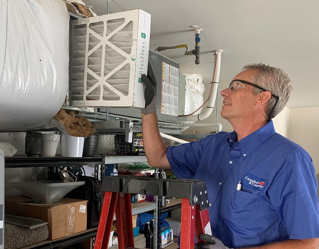 Campbell & Company technician installing furnace filter