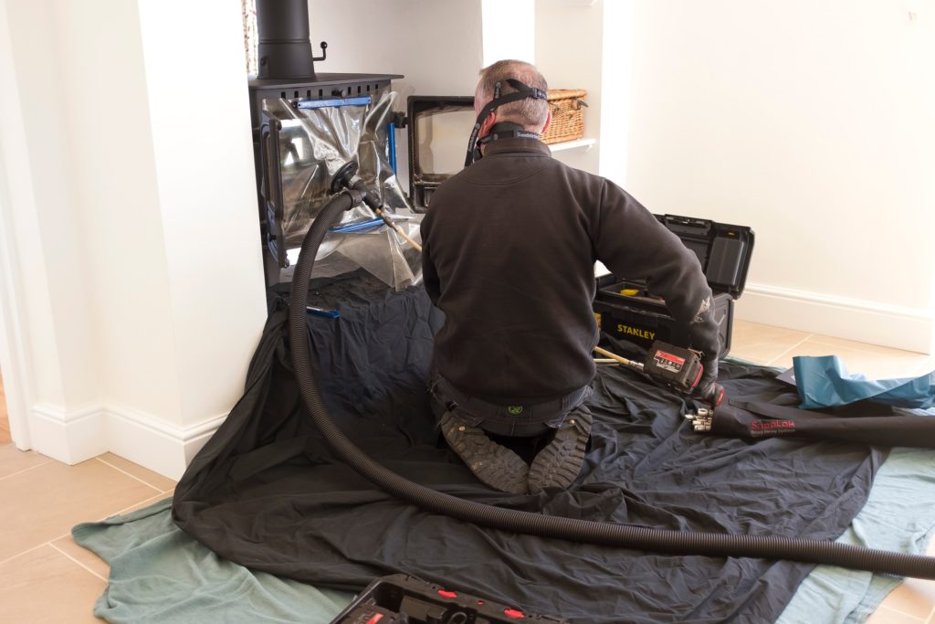 An expert service technician performing a chimney cleaning.