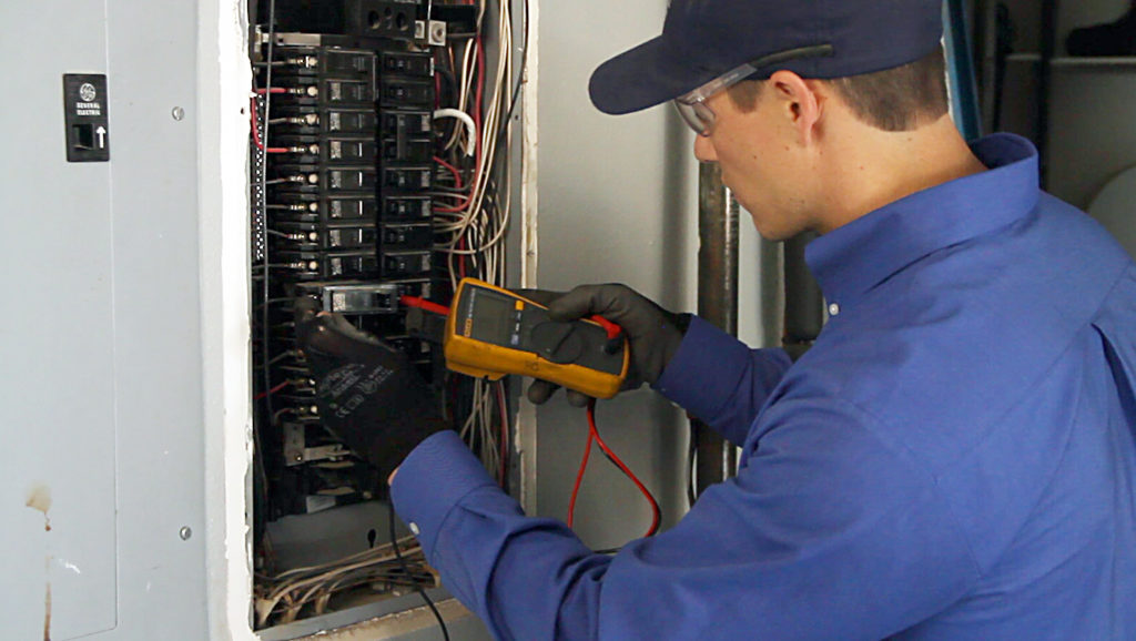 Close-up of a Campbell & Company contractor checking an electrical panel