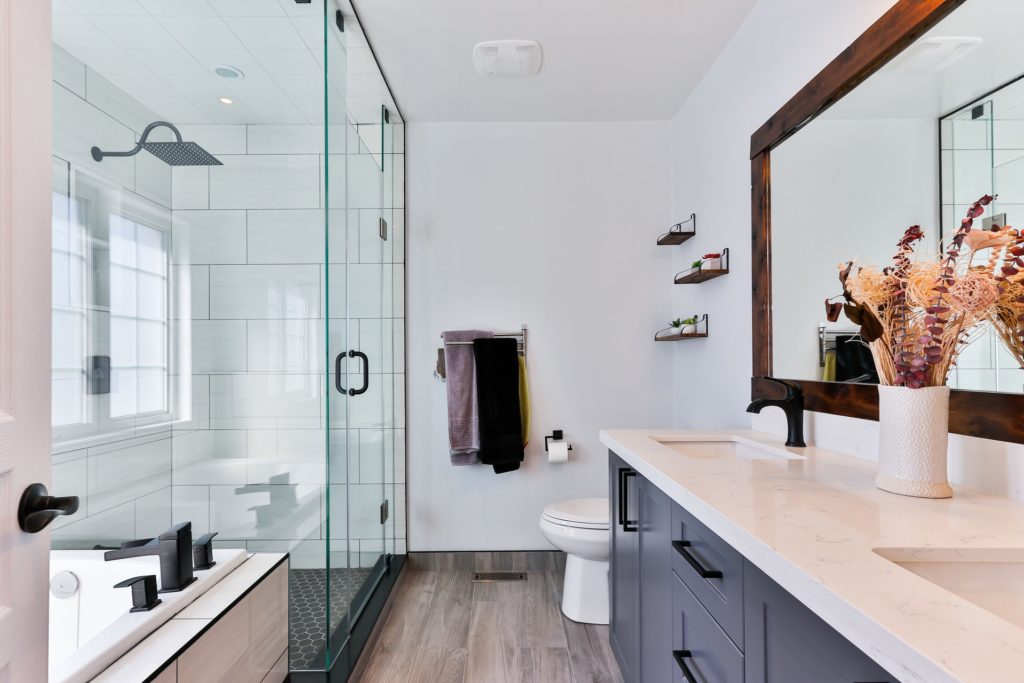 Modern bathroom with double sinks, glass shower enclosure, and soaking tub