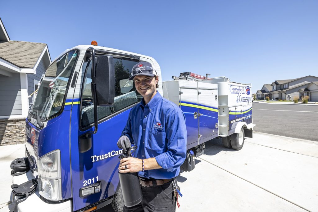 Campbell service technician smiling in front of company truck