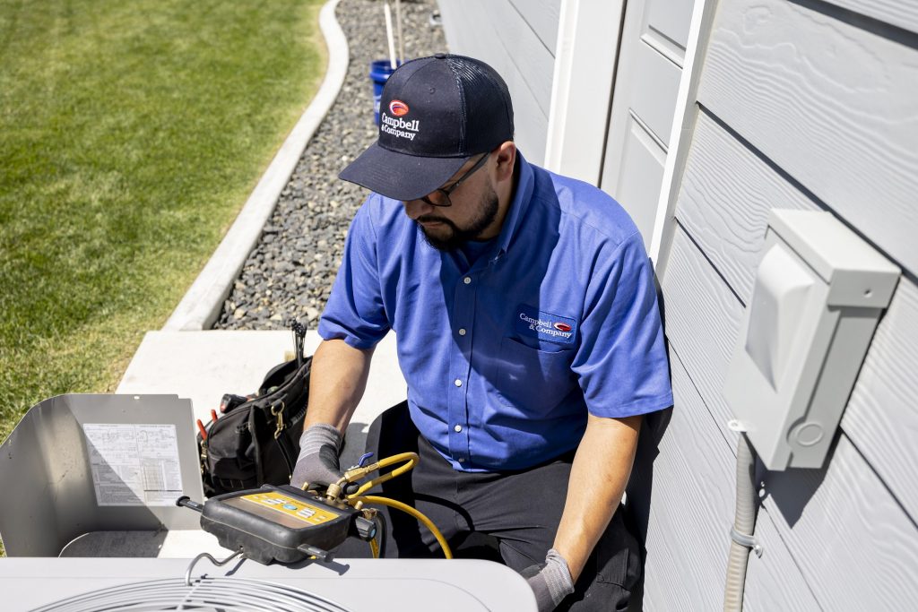 a technician performing an AC tune-up outside