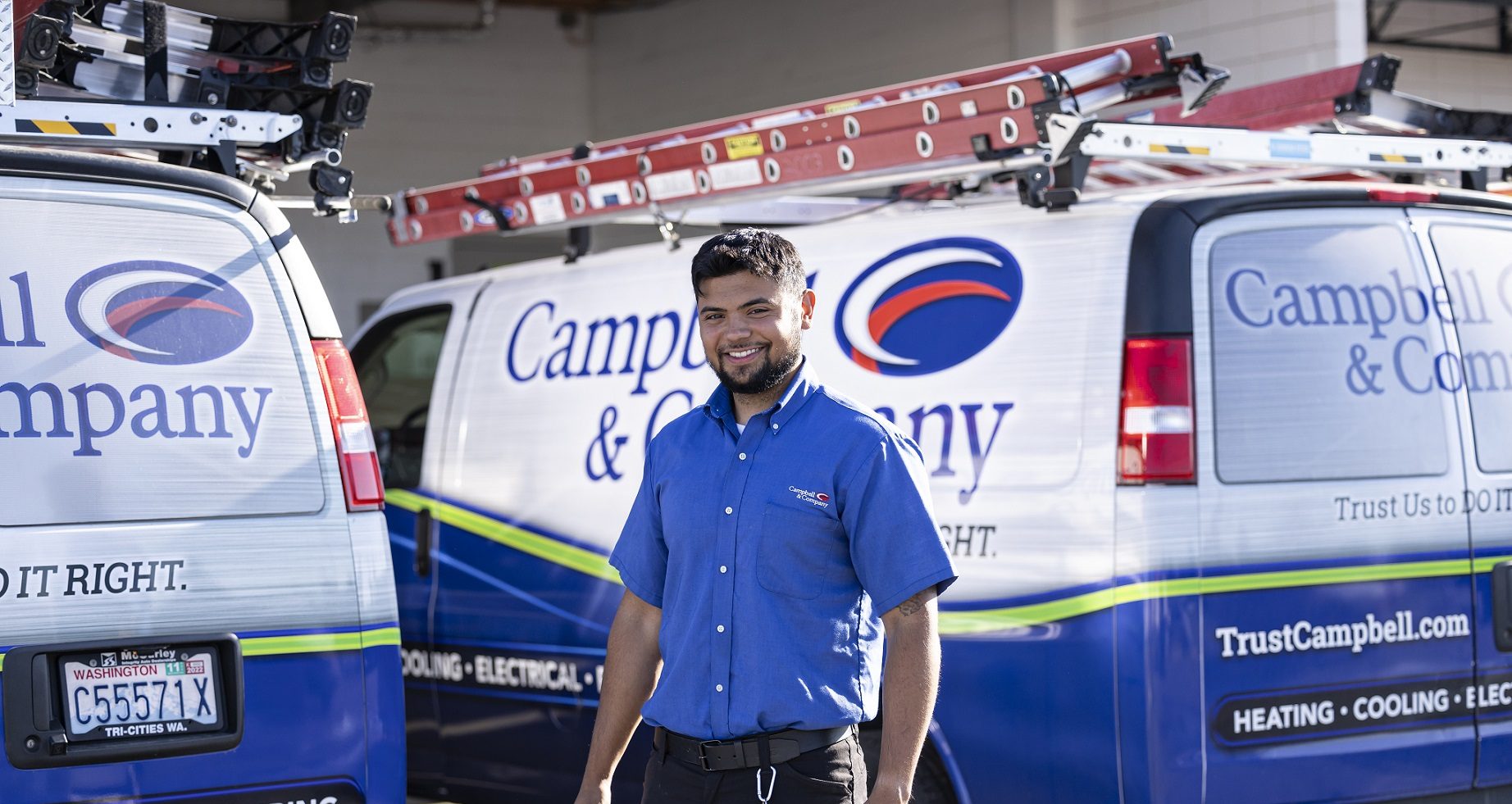 Campbell & Company hvac technician smiling in front of service van