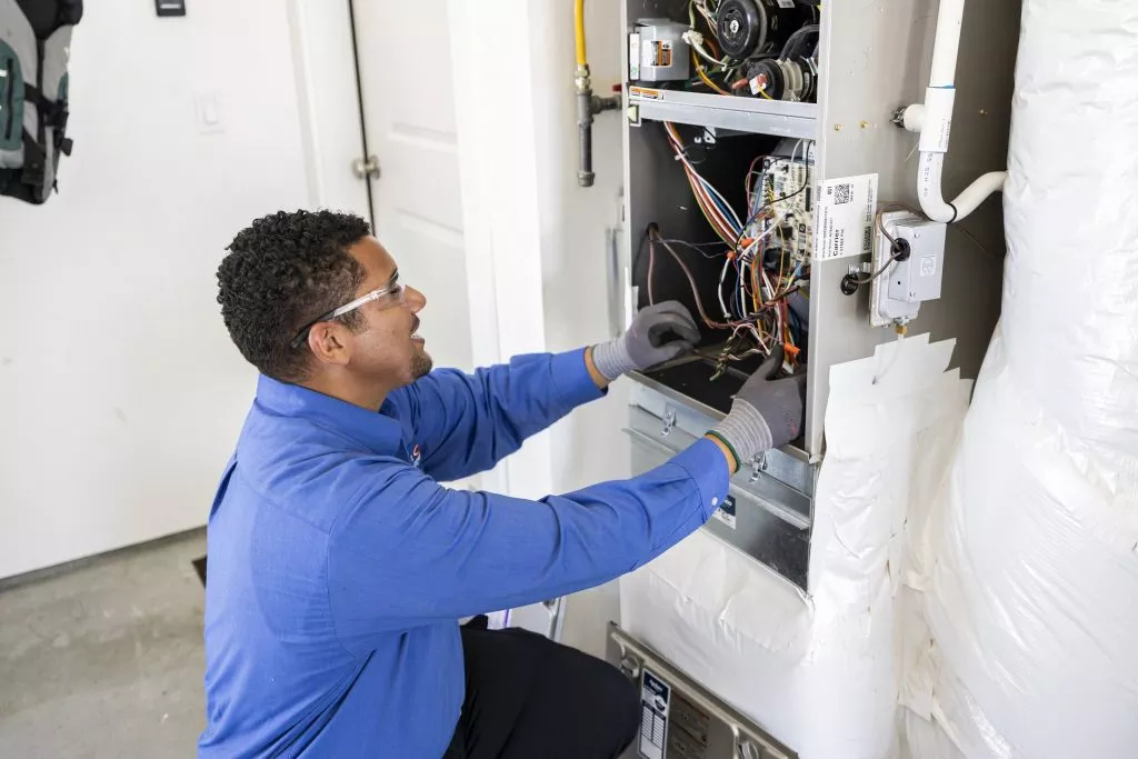 Technician fixing an air conditioner unit for HVAC system.