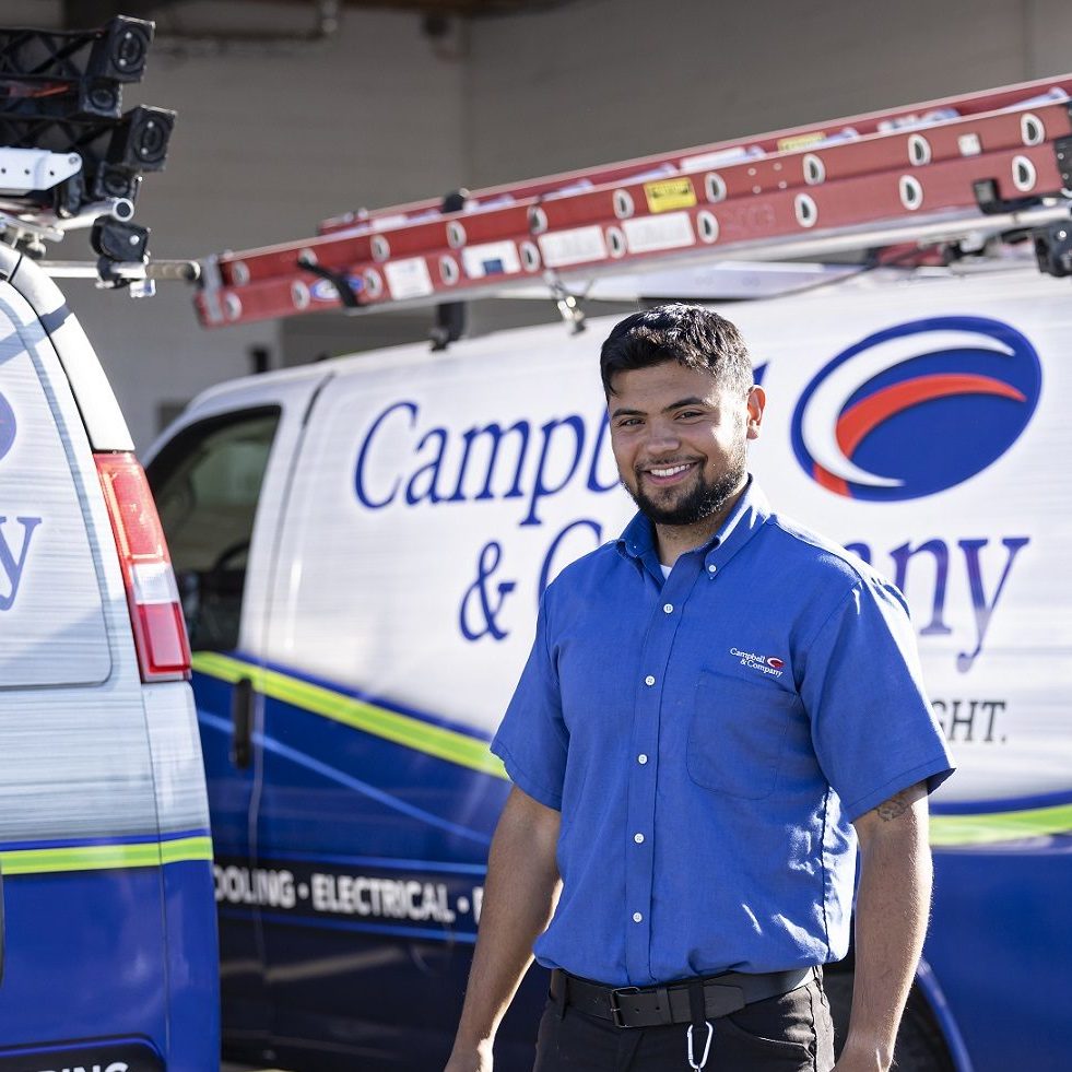 Campbell & Company technician smiling in front of service van