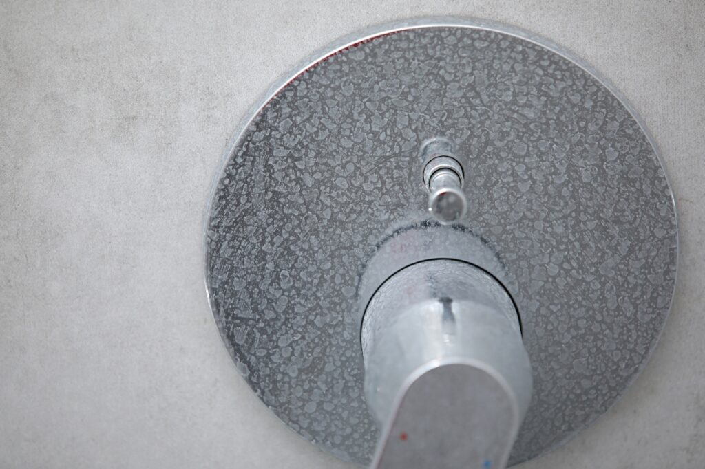 Limescale and soap scum on shower head from hard water