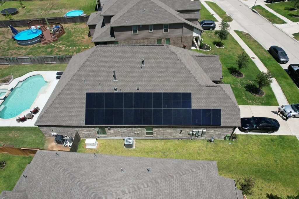 Aerial view of a house with solar panels on the roof.