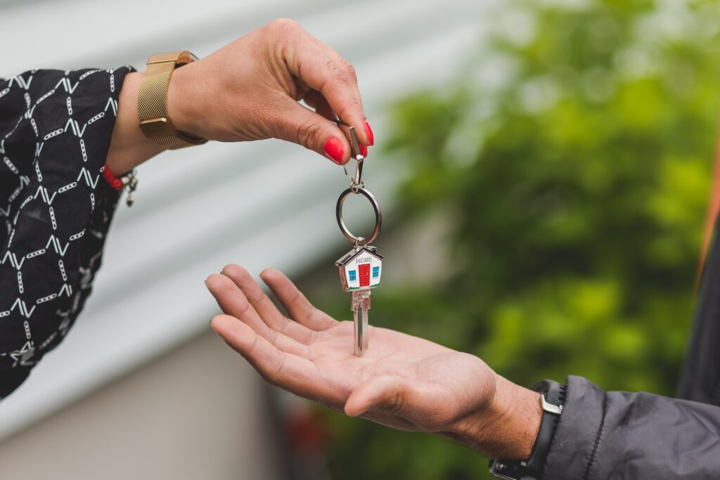 Home buyer and seller exchanging keys to a newly purchased home